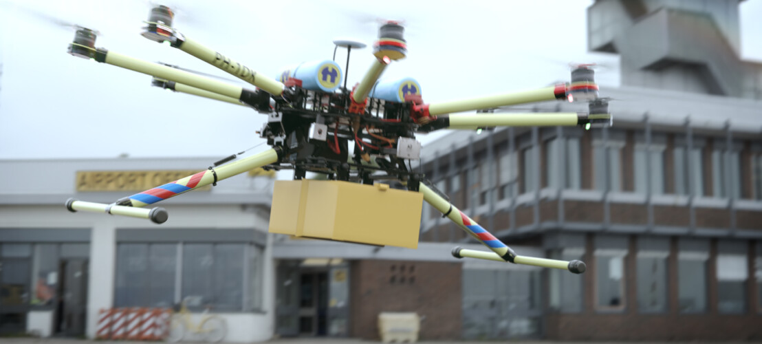 Medical Delivery drone vliegt voor een gebouw bij DroneHub Groningen Airport Eelde.
