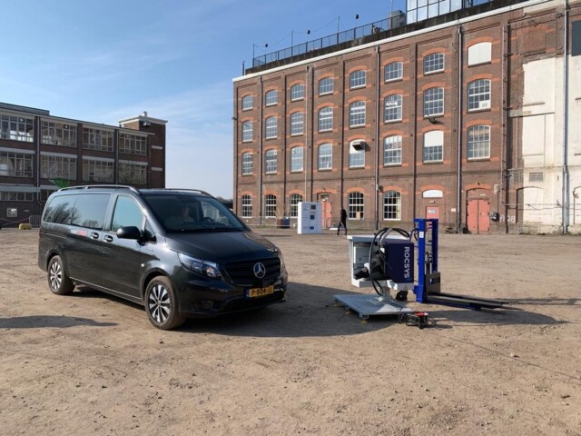 Onbemande zwarte Mercedes eVito bestelwagen en een onbemand oplaadpunt voor een gebouw op het Suikerterein in Groningen.